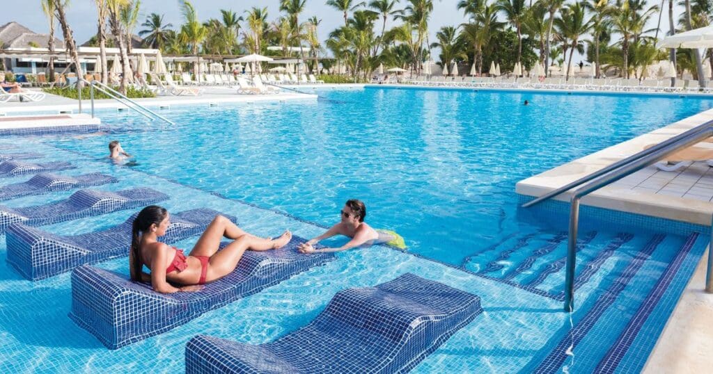 destination wedding guests relaxing at the pool at an all-inclusive resort in Punta Cana Dominican Republic
